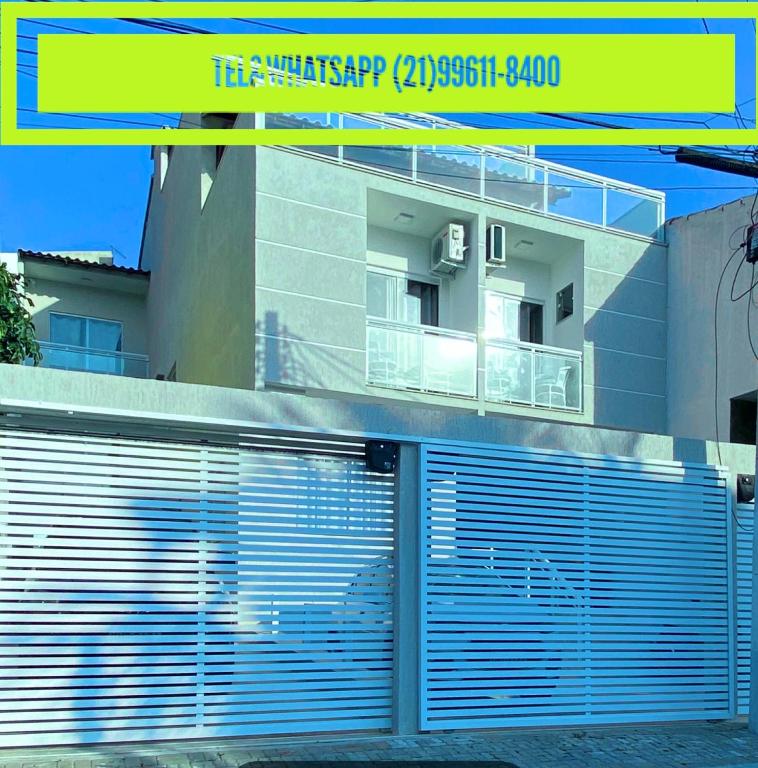 a building with blue garage doors on the side of it at Mirante dos Anjos Suítes in Arraial do Cabo