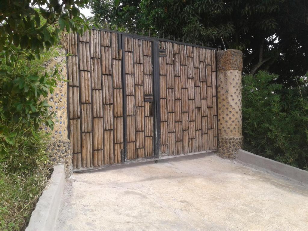 a wooden fence with a gate on top of it at Plastic Bottles House in Entebbe
