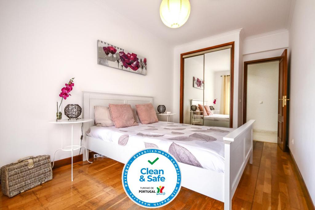 ein sauberes und sicheres Schlafzimmer mit einem Bett und einem Spiegel in der Unterkunft Apartamento Tejo in Cacilhas