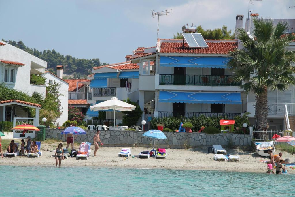 un grupo de personas en una playa cerca del agua en Iris Seafront Apartments, en Fourka