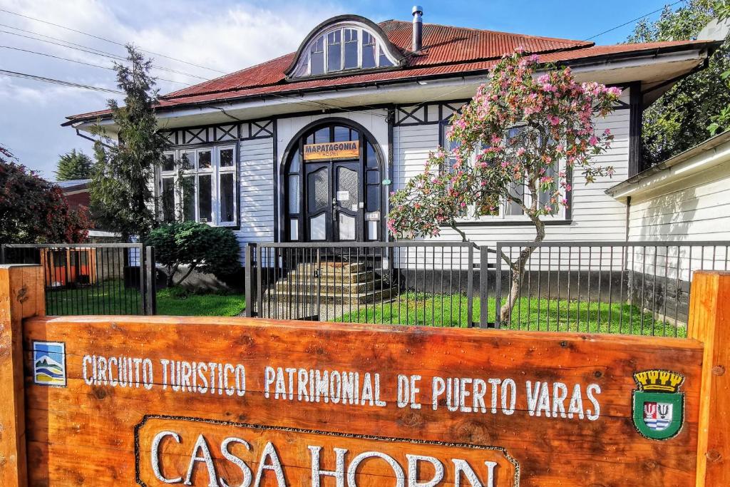 une maison avec un panneau devant elle dans l'établissement MaPatagonia Hostel Casa Patrimonial, à Puerto Varas