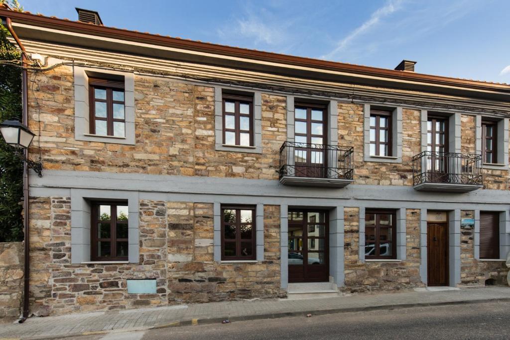 un vieux bâtiment en briques avec des fenêtres sur une rue dans l'établissement Posada Sierra de la Culebra, à Ferreras de Abajo