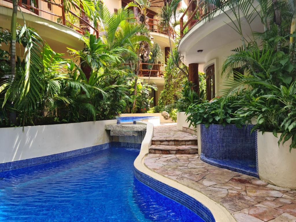 a pool in the middle of a building with plants at Luxury Villa steps to the beach & 5ta av, AMAZING in Playa del Carmen
