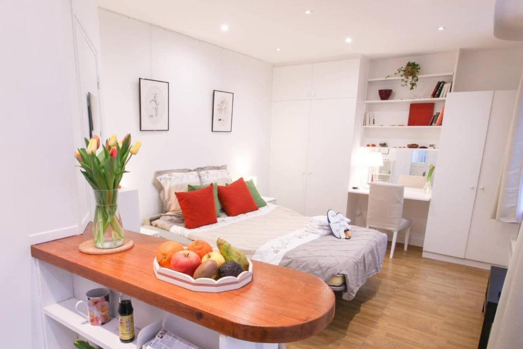 a living room with a bed and a table with a bowl of fruit at GuestReady - Charming Studio 5 mins to Pantheon in Paris