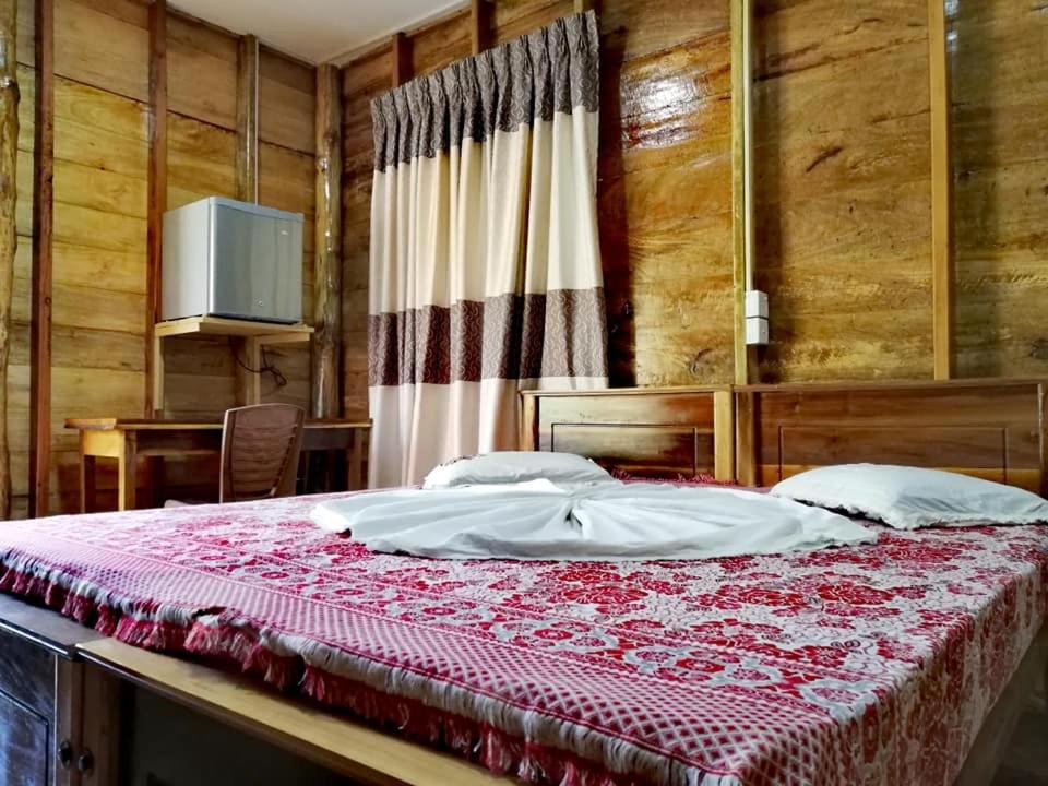 a bedroom with a large bed with a red blanket at Sea View Resort in Kallady