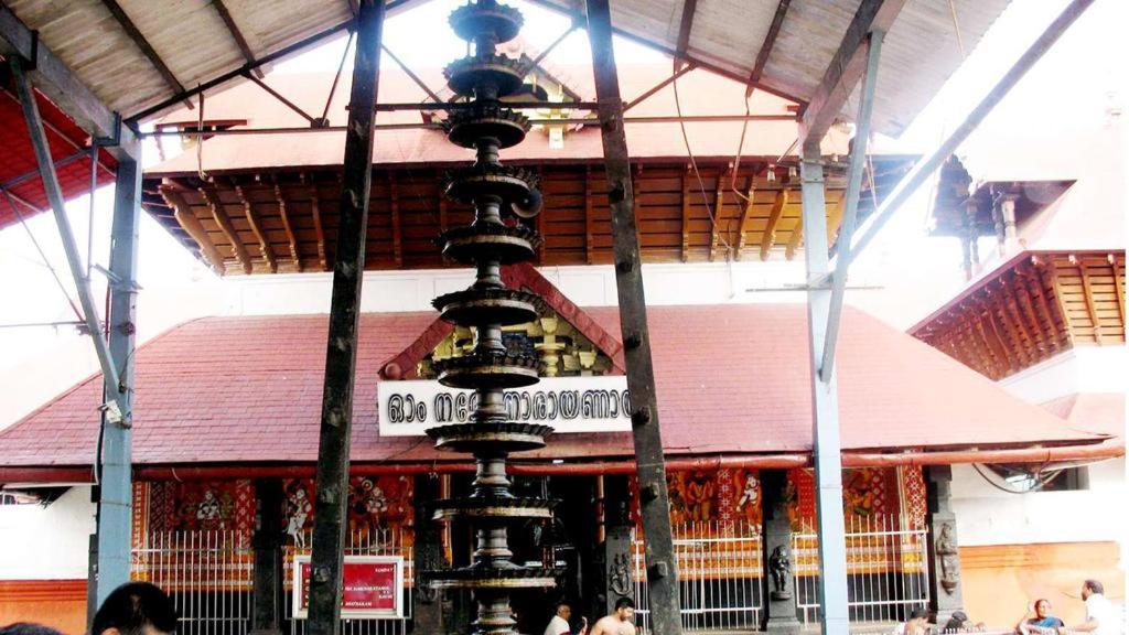 a building with a street sign in front of it at Kairali Tourist Home in Guruvāyūr