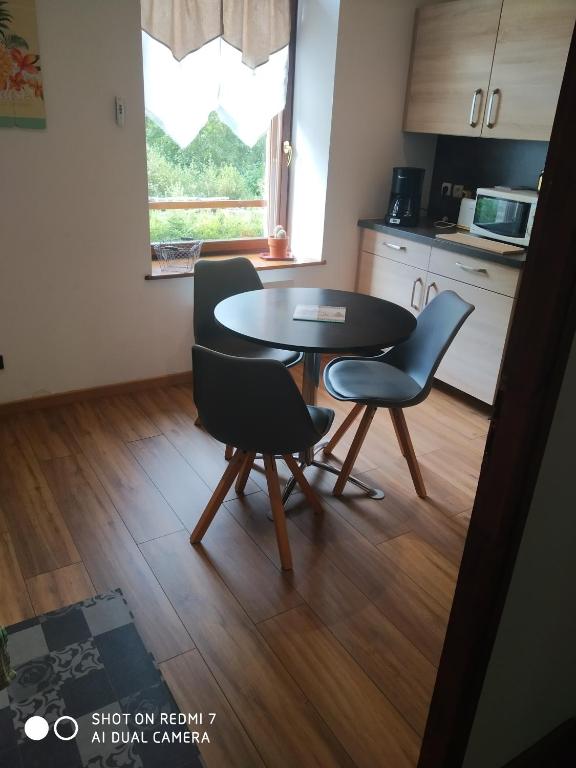 a kitchen with a table and chairs in a room at Les mimosas in La Bresse