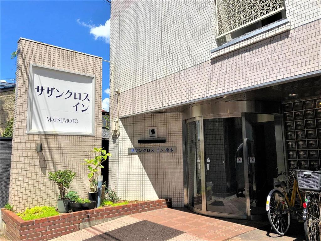 a building with a sign on the side of it at Southern Cross Inn Matsumoto in Matsumoto