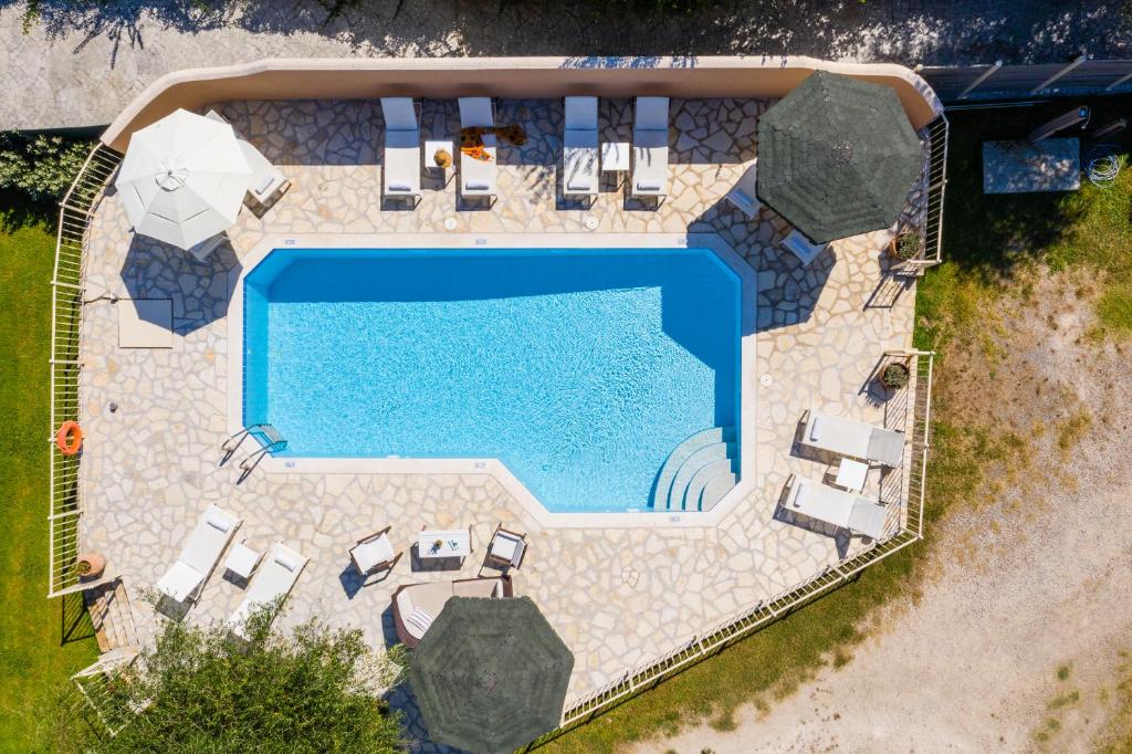 an overhead view of a swimming pool with patio furniture and a swimming poolvisorvisor at Villa St. Nicholas House & Guest Apart. in Dassia