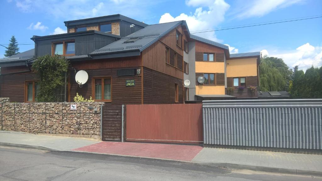drewniany dom z ogrodzeniem i bramą w obiekcie Pokoje Gościnne Jaga w Kielcach