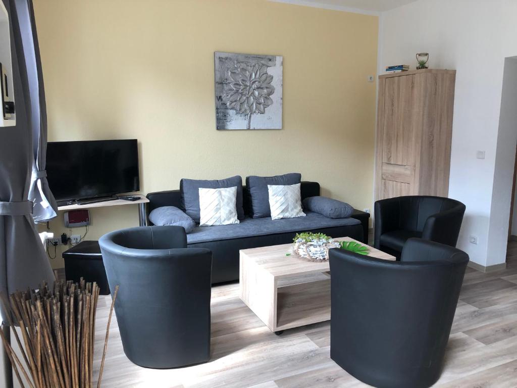 a living room with a blue couch and chairs at Appartements Nordhausen in Nordhausen