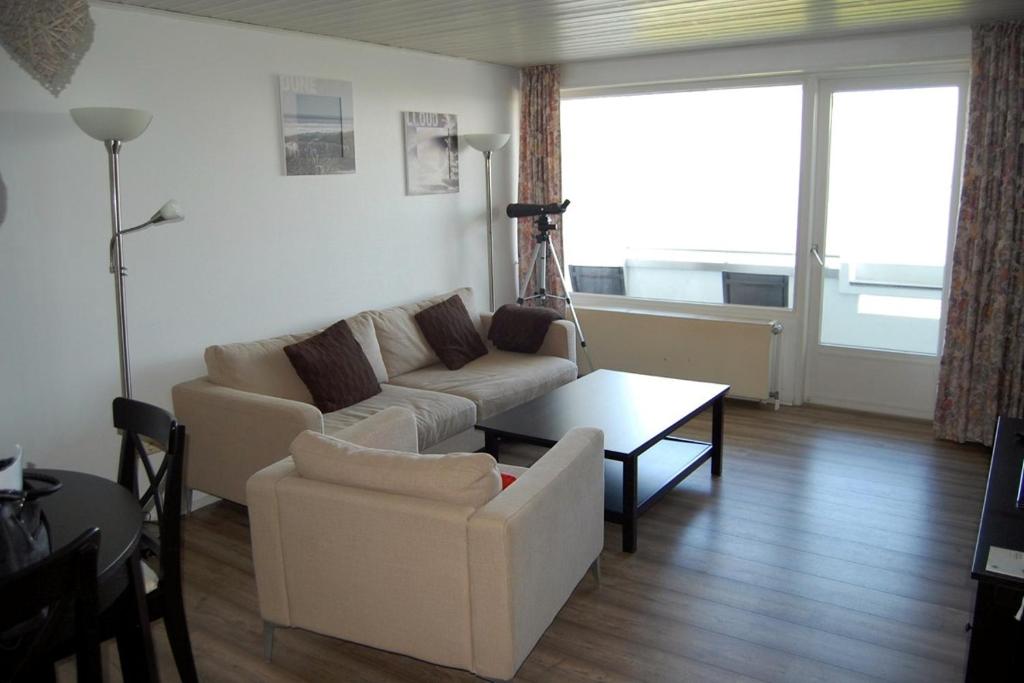 ein Wohnzimmer mit einem Sofa und einem Tisch in der Unterkunft Haus Nautic Whg. 810 in Cuxhaven