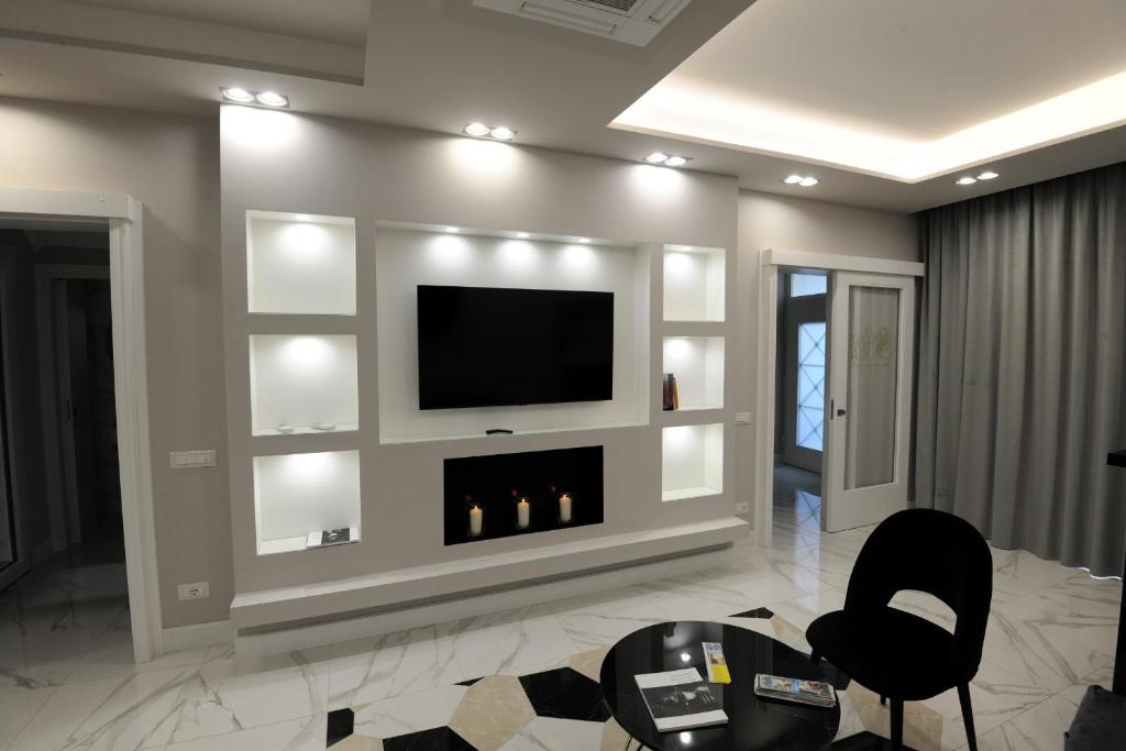 salon z telewizorem i kominkiem w obiekcie B&B La Dolce Vita w mieście Fondi