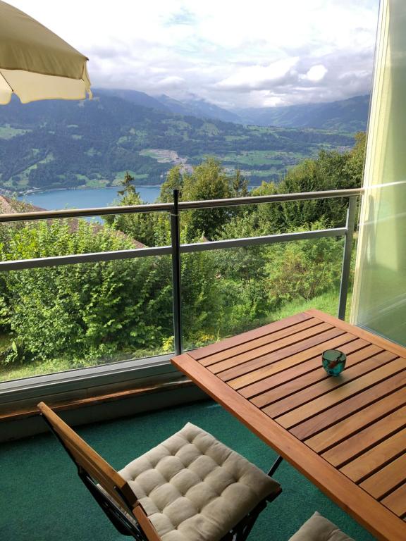 uma mesa e cadeiras numa varanda com vista em Wohnung mit See und Bergsicht im vier Sterne Hotel em Beatenberg