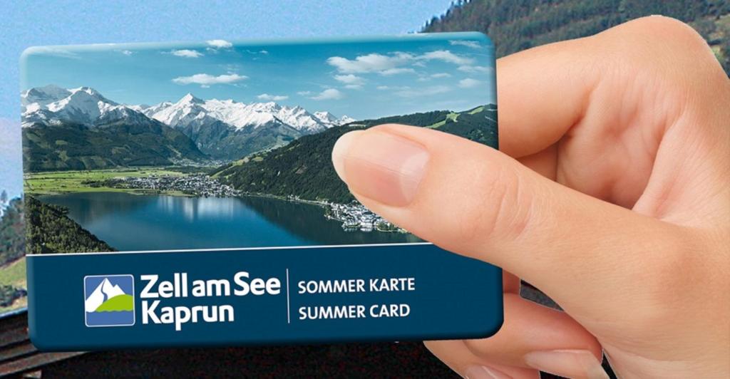 a hand holding a card with a picture of a lake at Hotel Garni Landhaus Gitti in Zell am See