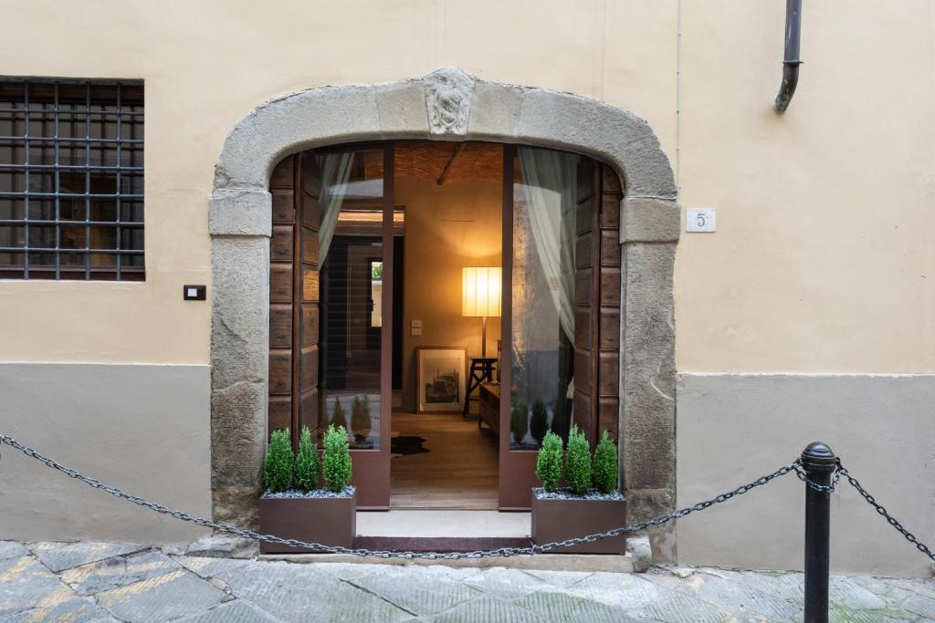 una entrada a un edificio con dos macetas en Fioraia5 Dimora, en Arezzo