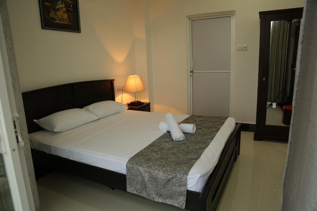 a bedroom with a bed with a white towel on it at SkyCasa Holiday Apartments in Mount Lavinia