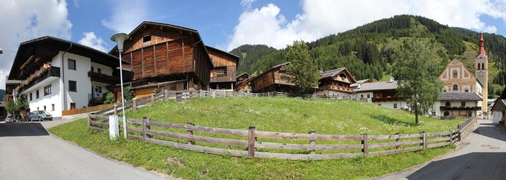 ein Dorf mit einem Hügel mit Häusern und einem Zaun in der Unterkunft Mascherhof in Obertilliach
