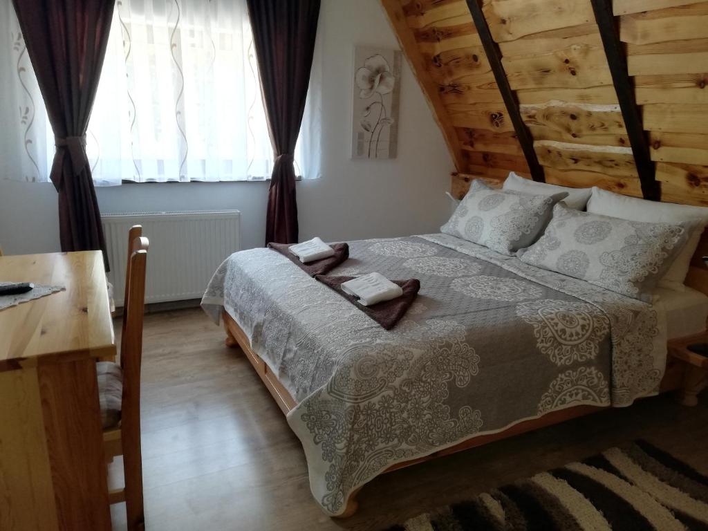 a bedroom with a bed and a table and a window at Rustic Lodge Plitvice 1 in Plitvička Jezera