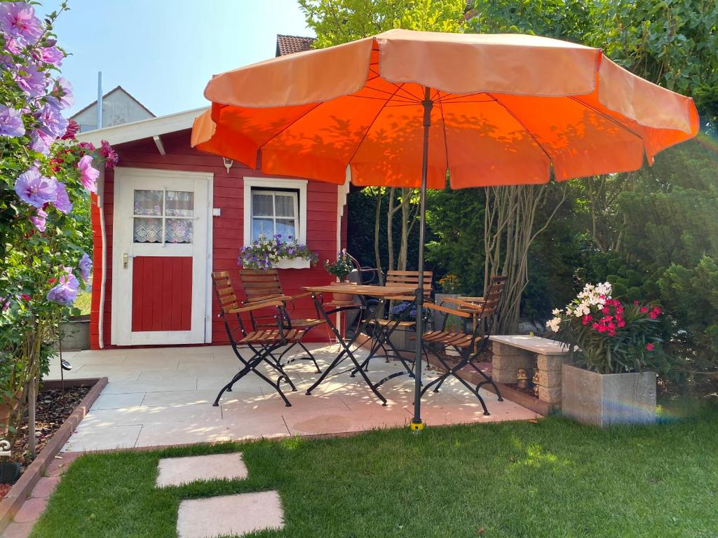 een patio met een tafel en stoelen en een parasol bij Ferienhaus Steinbach in Oberasbach