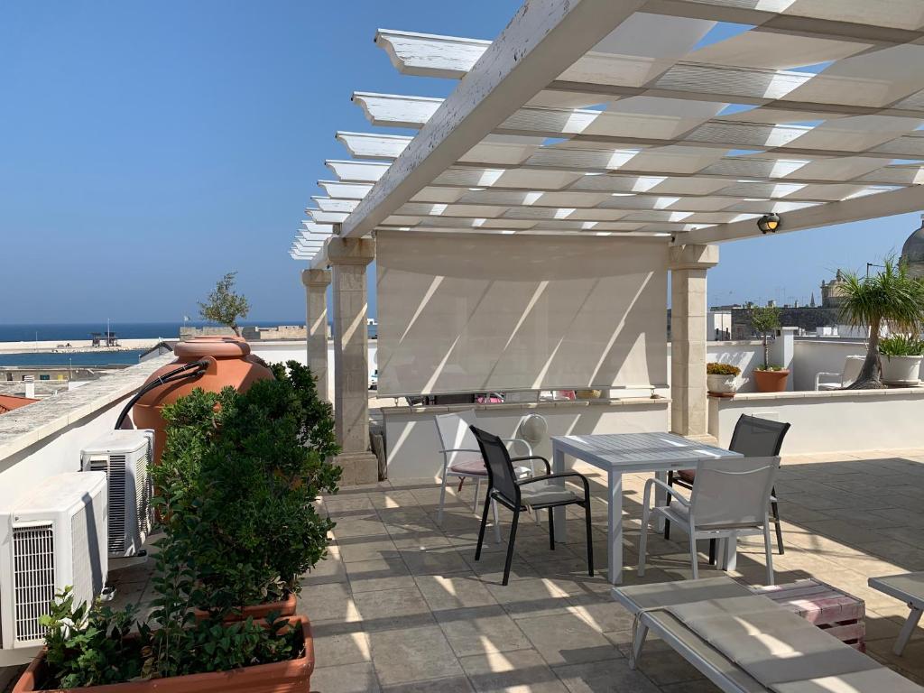 d'une terrasse sur le toit avec une table et des chaises. dans l'établissement Palazzo Dei Gesuiti, à Monopoli