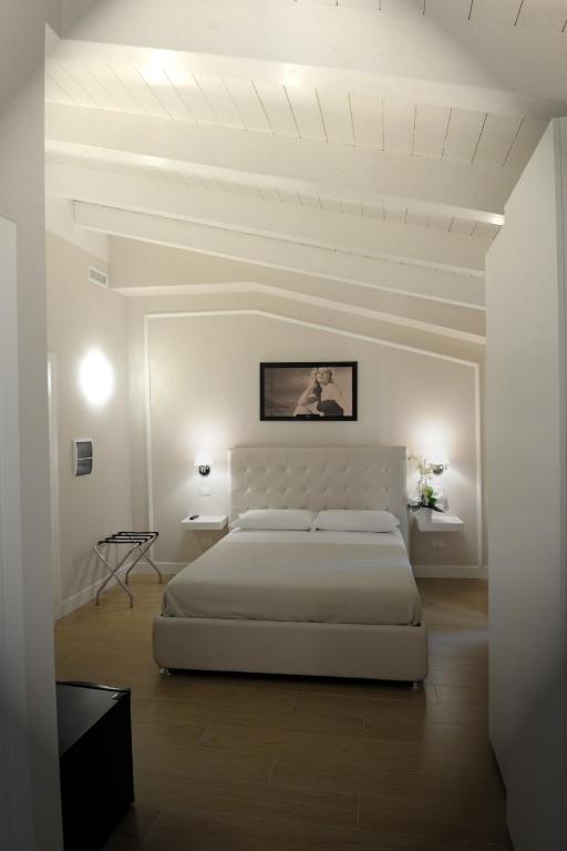Biała sypialnia z dużym łóżkiem i białym sufitem w obiekcie B&B La Dolce Vita w mieście Fondi