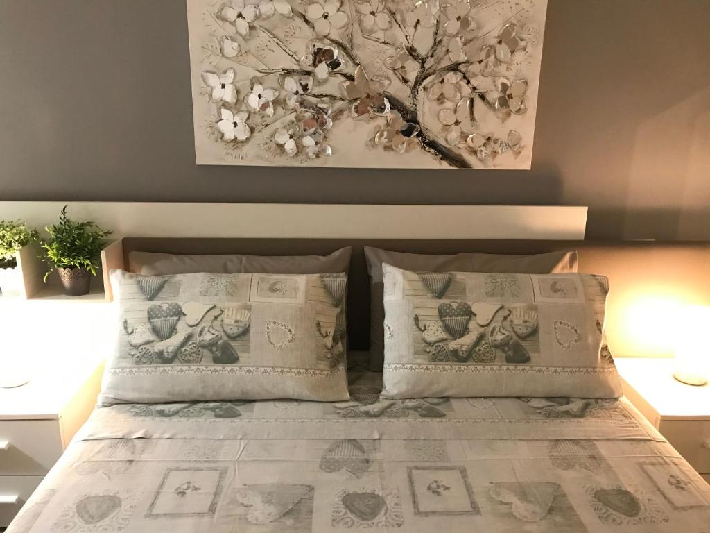 una camera con letto, 2 cuscini e un albero di Cà Nicola Cortemaggiore città d’arte a Cortemaggiore
