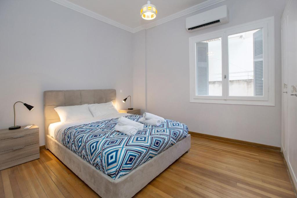 - une chambre blanche avec un lit et une fenêtre dans l'établissement Isora Apartment by GHH, à Athènes