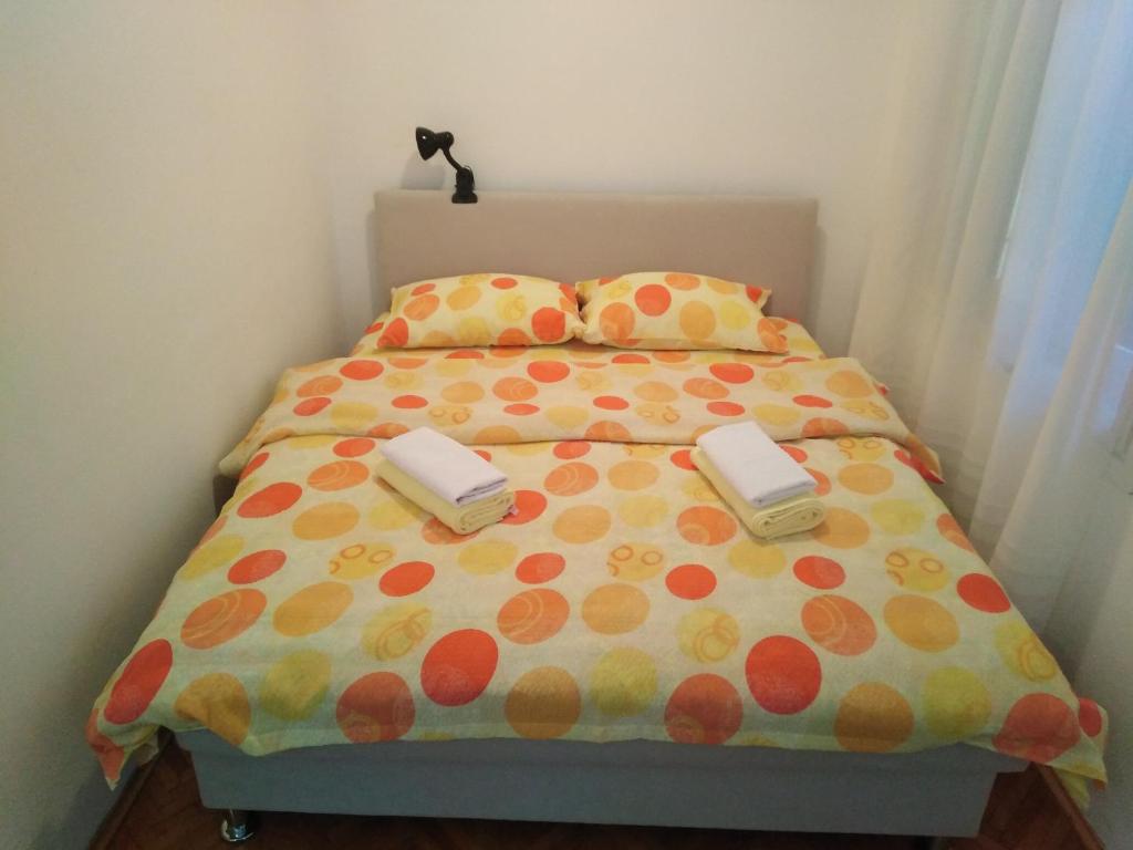a bed with a polka dot bedspread and two phones on it at Holiday Home Vladanka-Planinska kuća Vladanka in Biserske Kuće