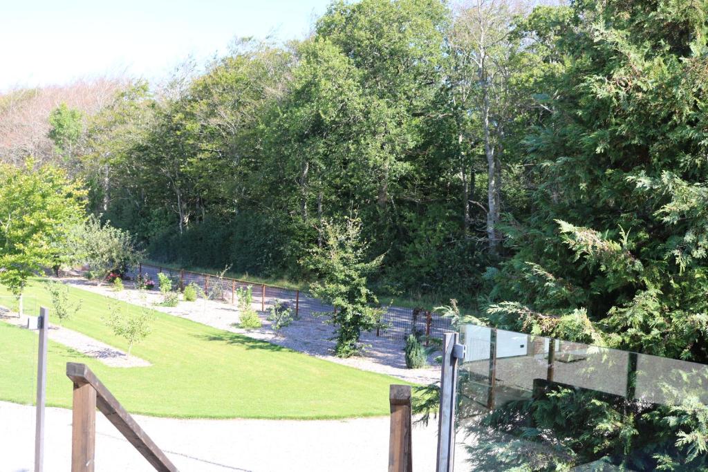 un jardín con valla, césped y árboles en Haramara, en Vester-Skerninge