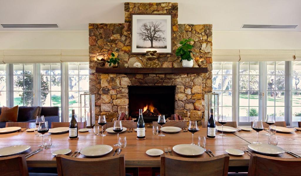 a dining room with a table and a fireplace at Cherubino Wines Guest Houses in Wilyabrup