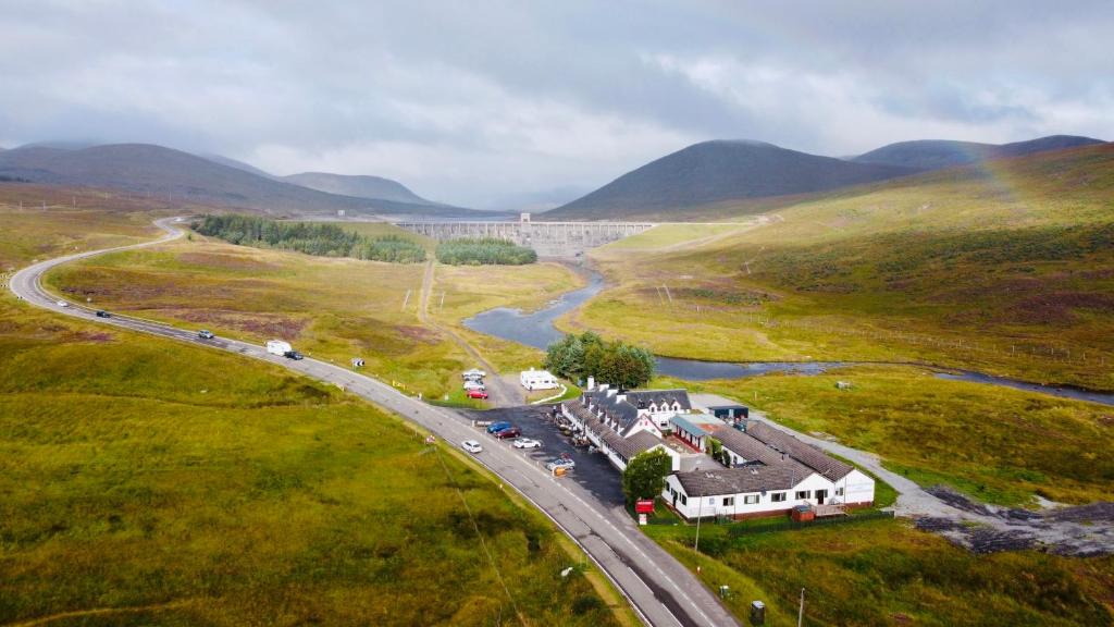 an aerial view of a road in a field with a river at Aultguish Inn in Garve
