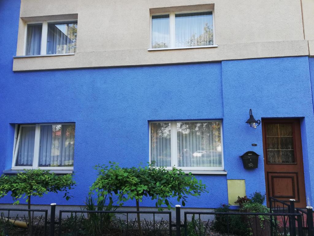 a blue facade of a house with a door at Pension Becker Luckenwalde in Luckenwalde