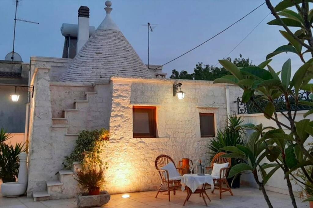 a house with a table and chairs in front of it at Trullo Pentimelle in Martina Franca