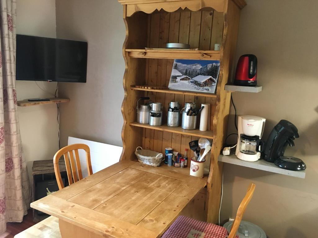 a wooden table in a room with a table and a shelf at Appartement aux Menuires in Les Menuires