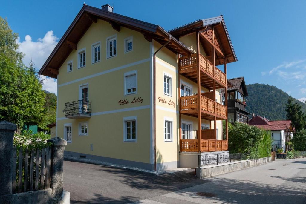 ein großes gelbes Gebäude mit einem Holzdach in der Unterkunft Villa Lilly - Luxus Appartements im Villenviertel in Bad Ischl
