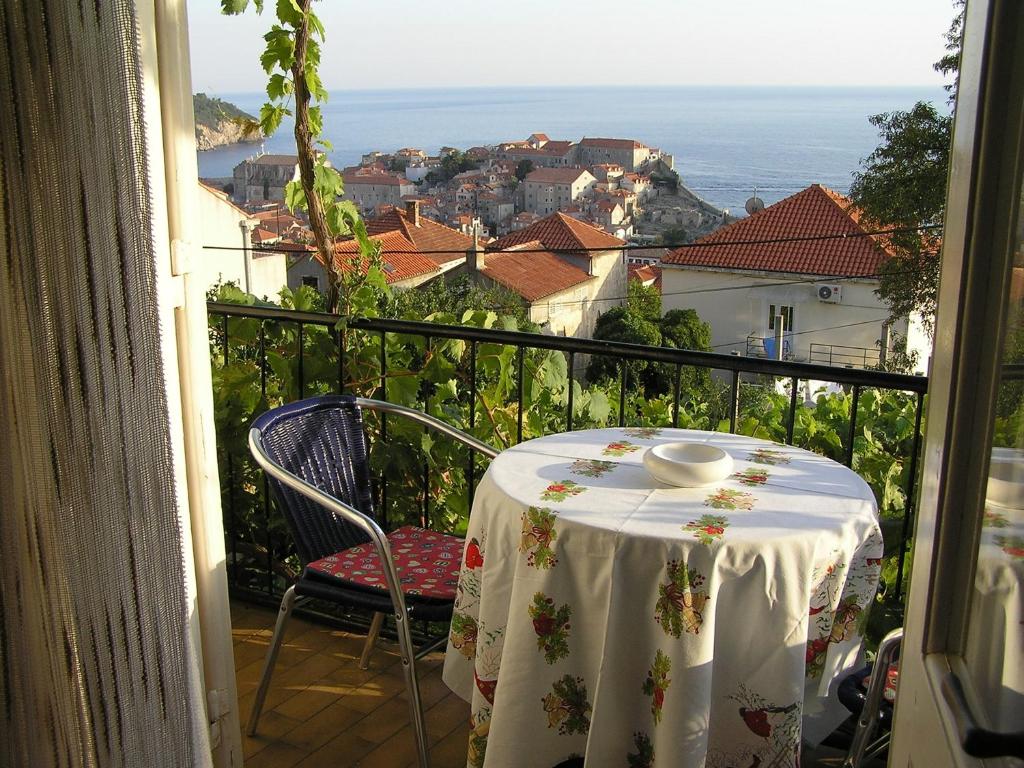 a table and chairs on a balcony with a view at Apartments Beslema in Dubrovnik