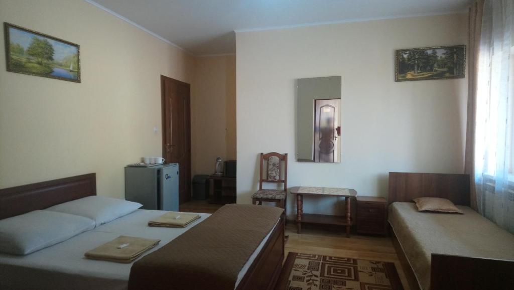 ein Zimmer mit 2 Betten und einem Sofa darin in der Unterkunft Садиба у Яноша in Wynohradiw