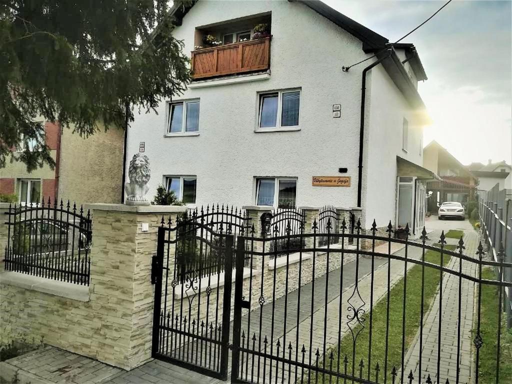 a white house with a black fence in front of it at Ubytovanie u Jozefa / Strba in Štrba