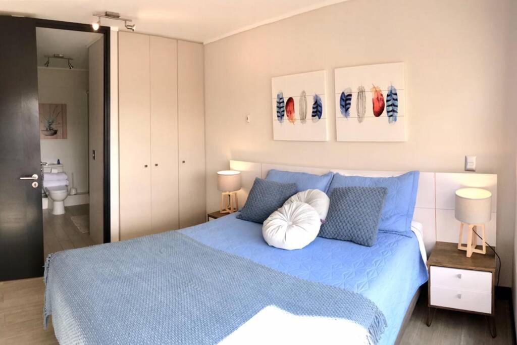 ein Schlafzimmer mit einem blauen Bett und einem weißen Kissen in der Unterkunft Ideal departamento en el corazón de Los Dominicos in Santiago