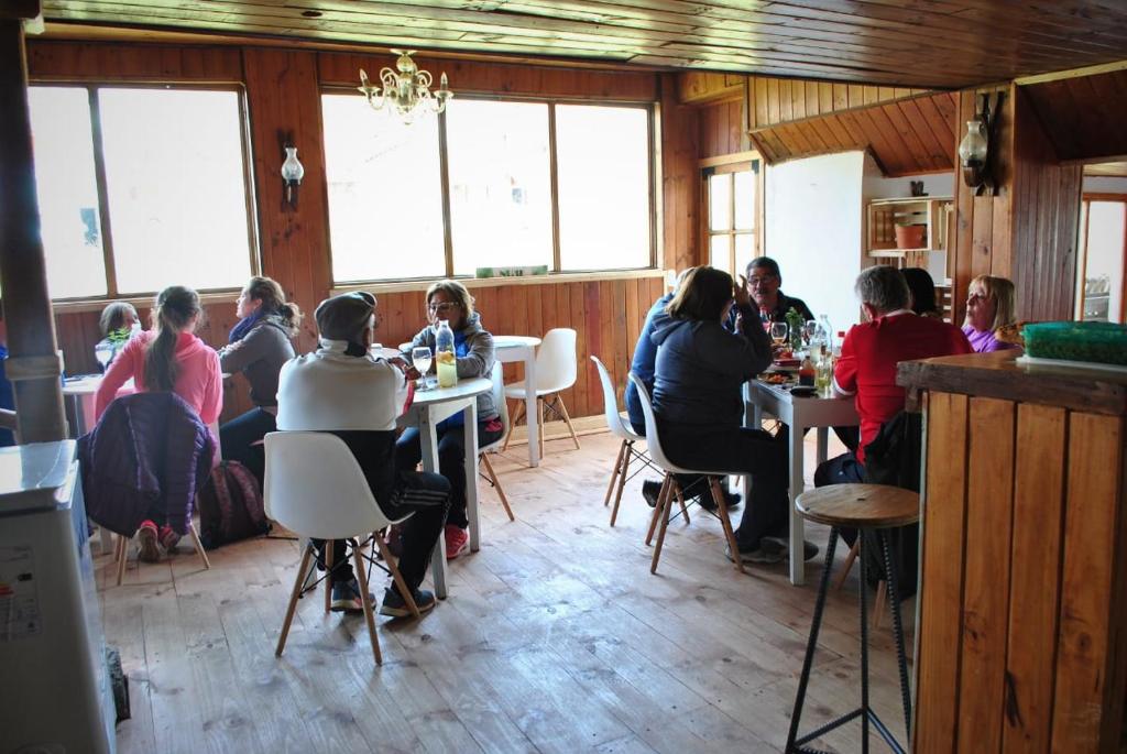 un grupo de personas sentadas en mesas en un restaurante en Copahue Hotel en Copahue