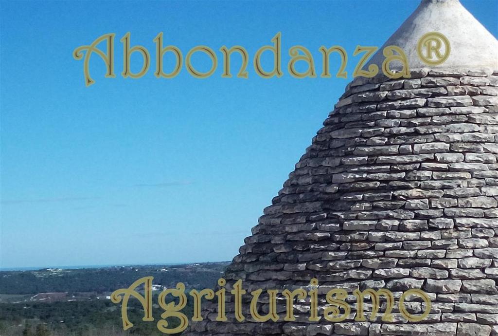 Una torre de piedra con el mundo y el medio de una pistola en Abbondanza® Agriturismo, en Alberobello