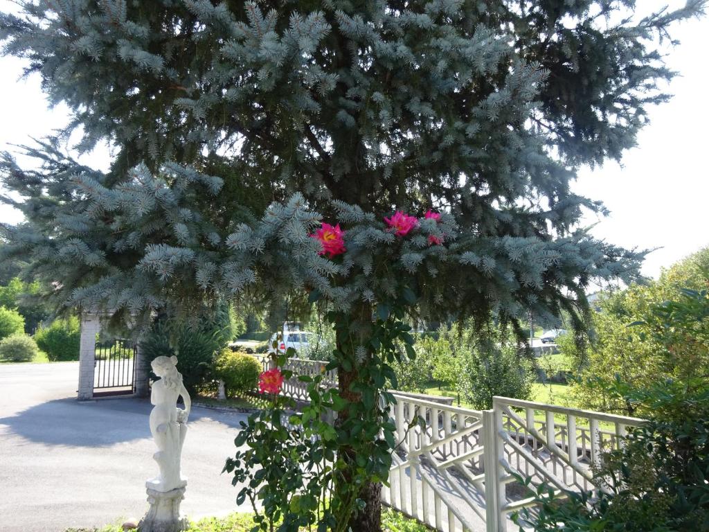un arbre avec des fleurs roses à côté d'une clôture dans l'établissement Rooms Kapelj, à Postojna