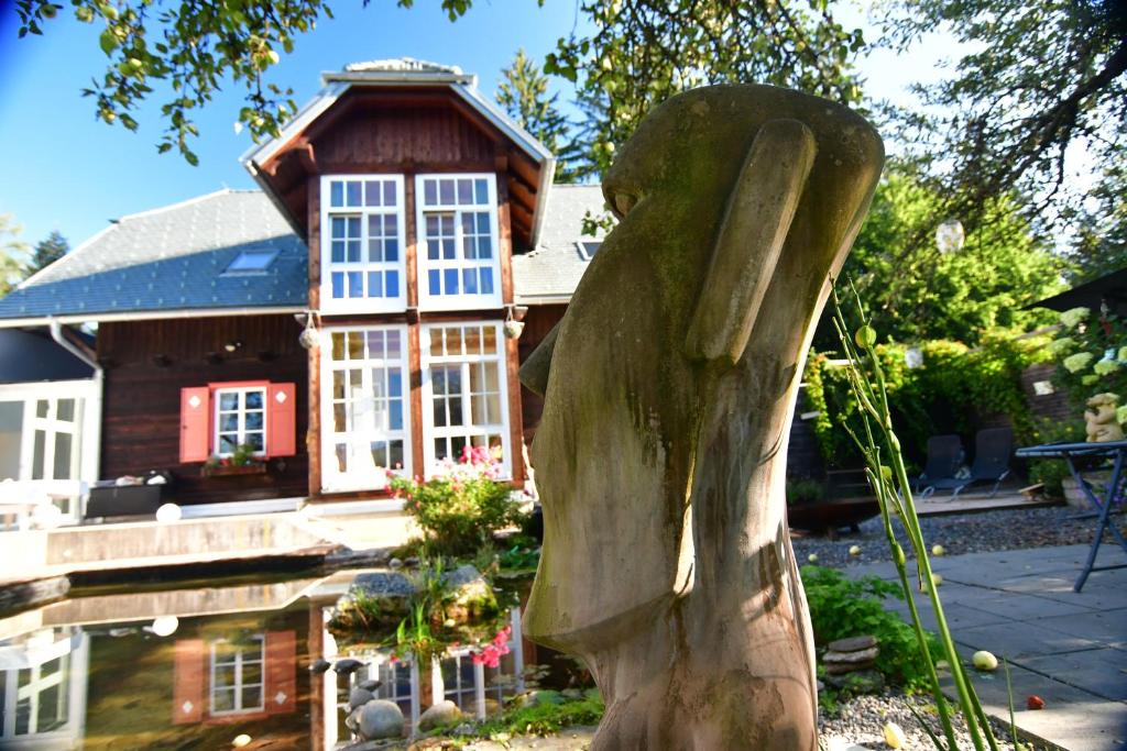 a wooden statue in front of a house at Naturforsthaus Gartenblick für tier- und naturverbundene Menschen in Preitenegg