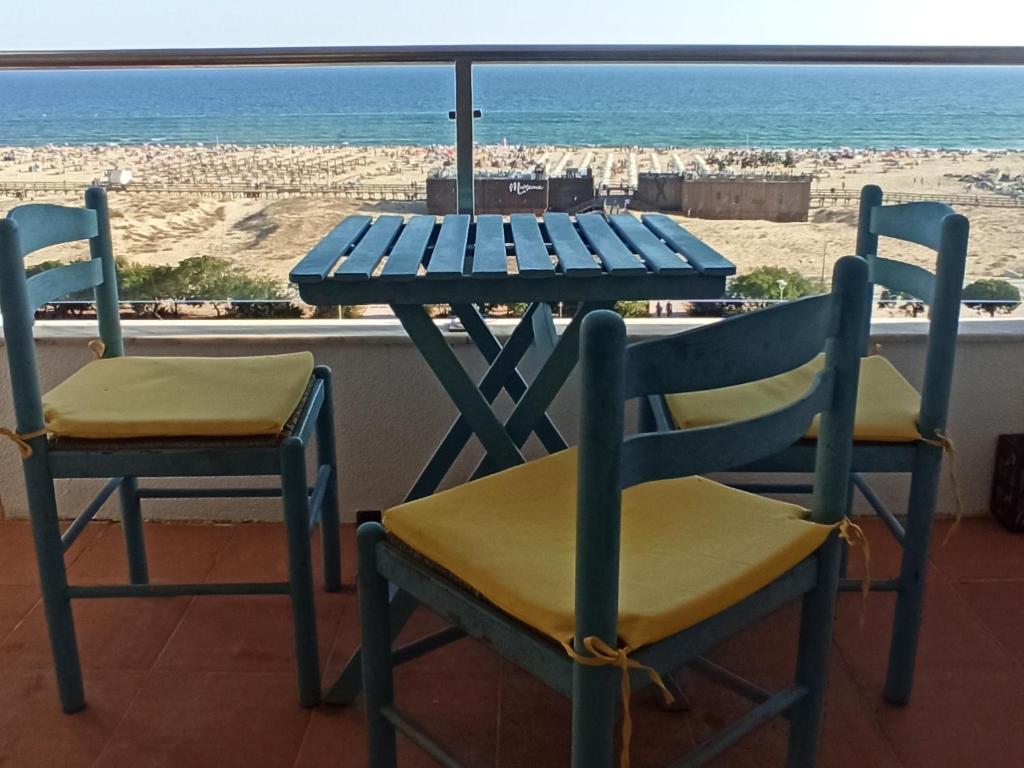 einen blauen Tisch und Stühle mit Blick auf den Strand in der Unterkunft Best Sea View Monte Gordo in Monte Gordo