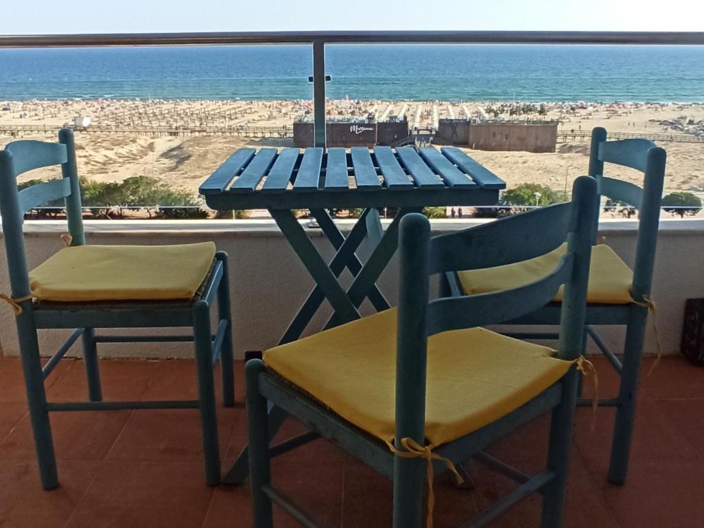 a blue table and chairs with a view of the beach at Best Sea View Monte Gordo in Monte Gordo