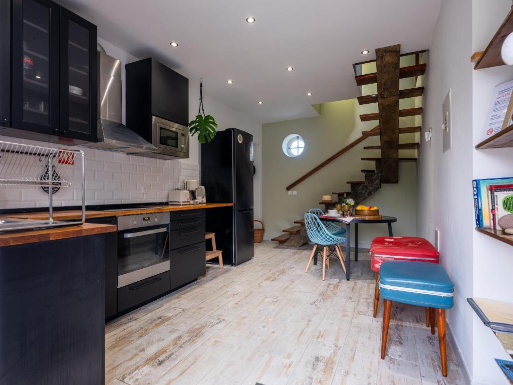 a kitchen with black cabinets and a table and chairs at Villa Várzea Hiker Nest in Várzea