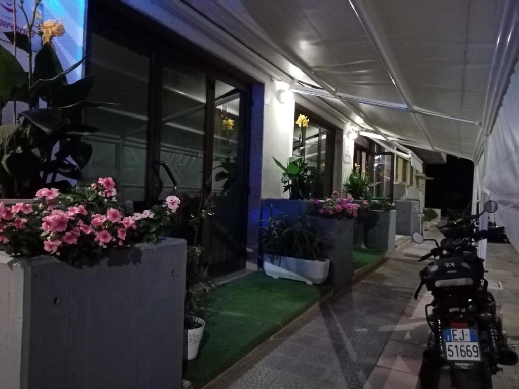 ein Motorrad, das vor einem Gebäude mit Topfpflanzen parkt in der Unterkunft B&B la Maison in Sammichele di Bari