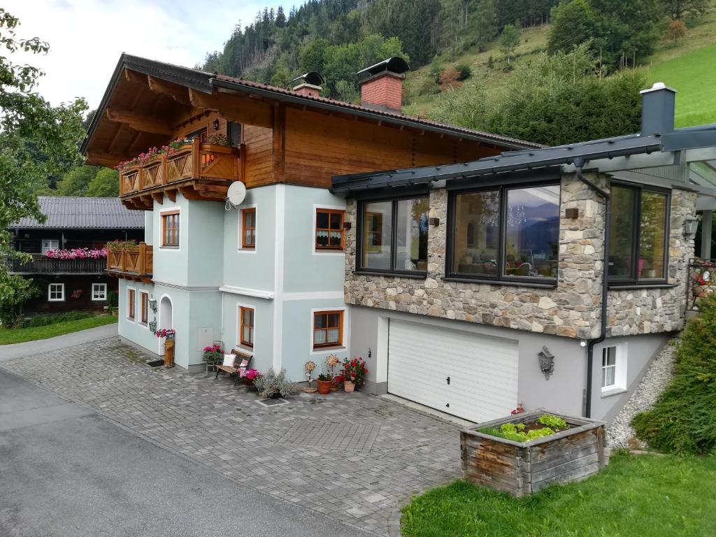 a house with a garage in front of it at Biobergbauernhof Bergzeit Apartment in Goldegg in Goldegg