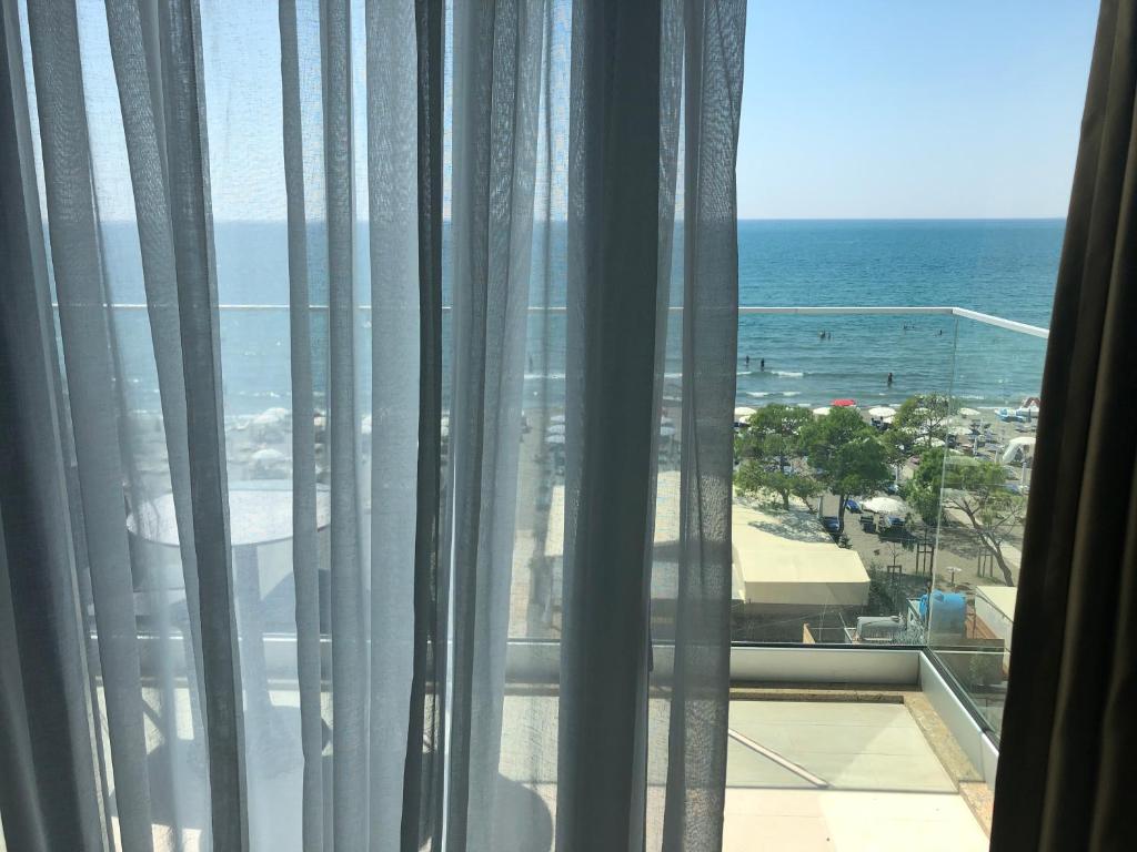 a view of the ocean from a hotel room window at Hotel Triumf Shengjin in Shëngjin